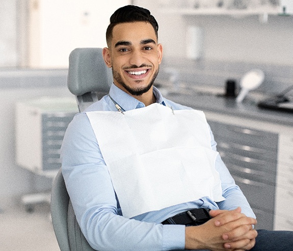 Patient smiling while sitting in treatment chair