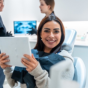 Woman smiling while holding handheld mirror